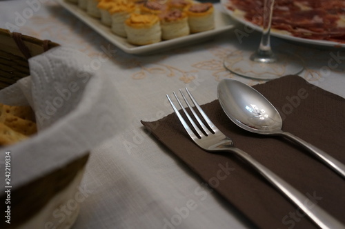 Silver cutlery for dinner with plates and napkins