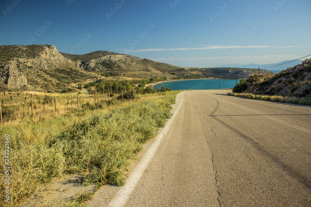 empty curved old car road in dry summer yellow highland nature environment  landscape with sea bay background view