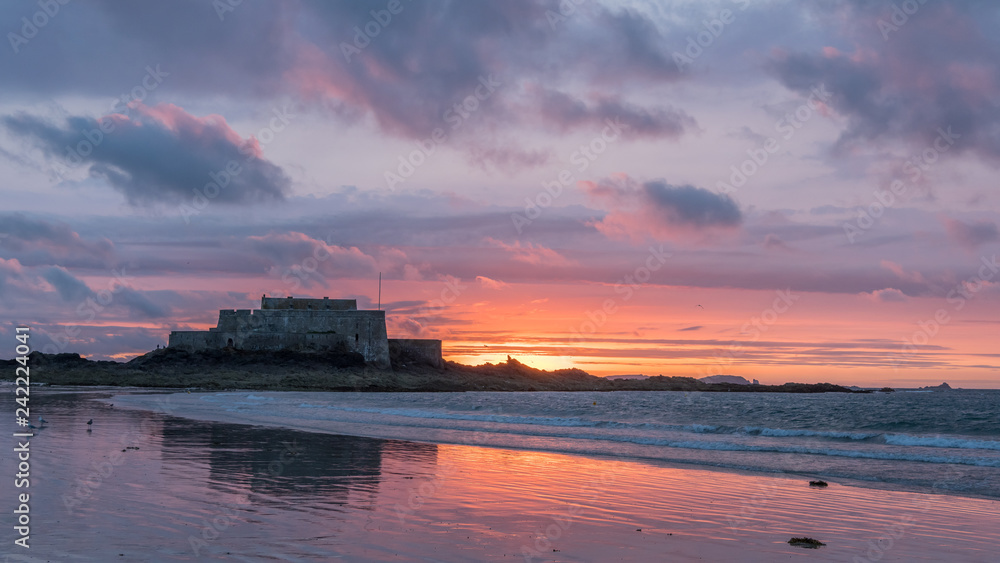 Sunset on the beach and Fort National during low tide in Saint Malo