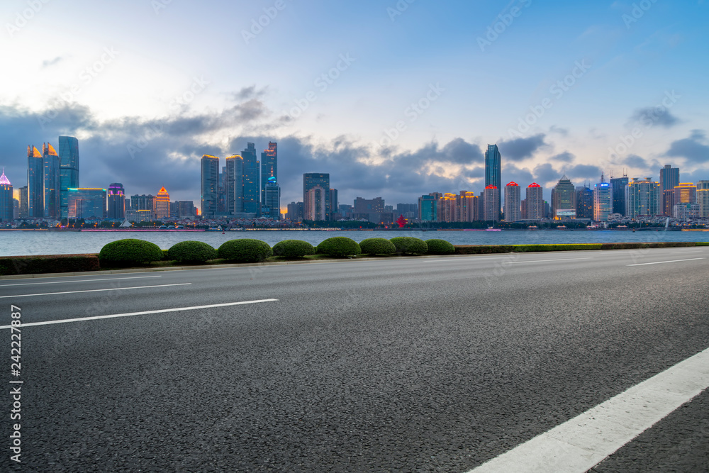 Empty asphalt road along modern commercial buildings in China,s cities Empty asphalt road along modern commercial buildings in China,s cities
