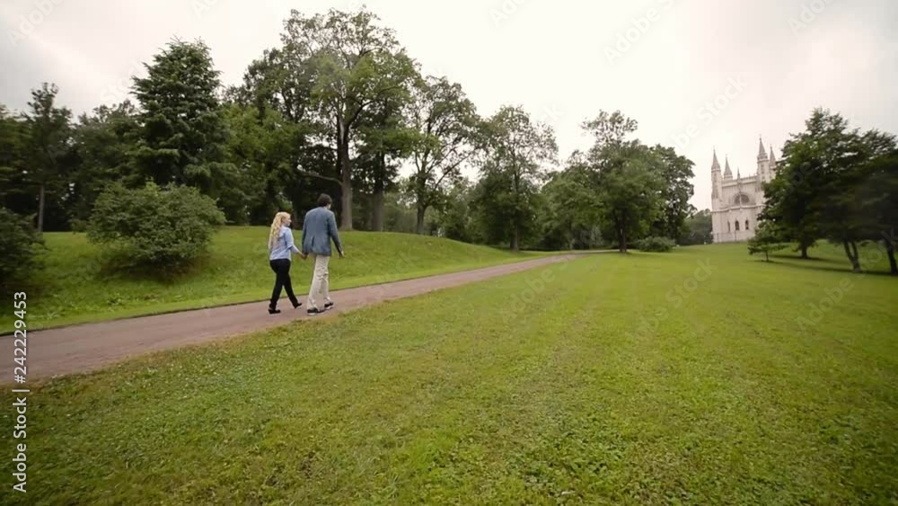Young lovely couple walking in a park in summer. Romantic dating or lovestory. Young lovely couple walking in a park in summer. Romantic dating or lovestory.