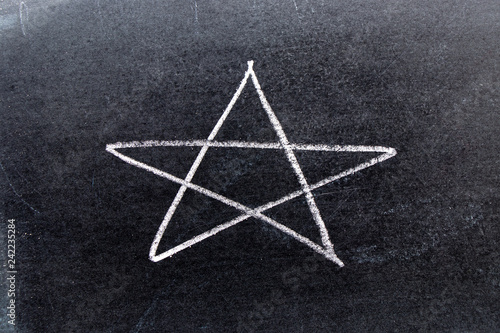 White chalk hand drawing in star shape on black board background