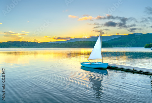 Εκτύπωση καμβά Lonely sailboat in the beautiful sunset with sun stars shines from sky and the s