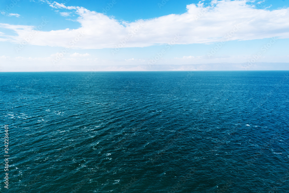 Blue Dead Sea and cloudy sky waves