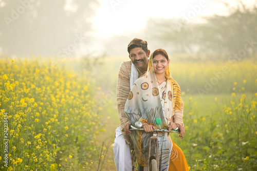 Rural Indian family with bicycle in agricultural field