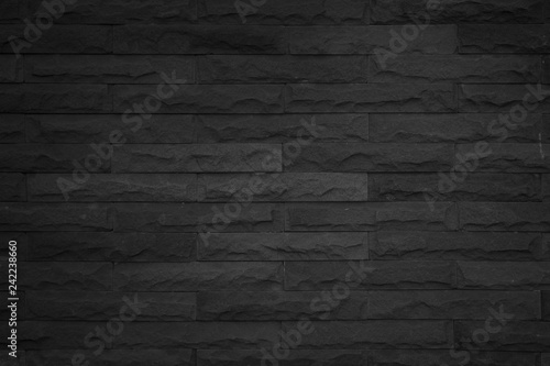 Seamless Black pattern of decorative brick sandstone wall surface with concrete of modern style design decorative uneven have cracked realmasonry wall of multicolored stones or blocks white cement.