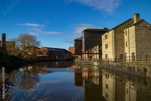 Old buildings on the side of the Leeds/ Liverpool Canal as the morning sun rises. Wigan Pier, Wigan, England