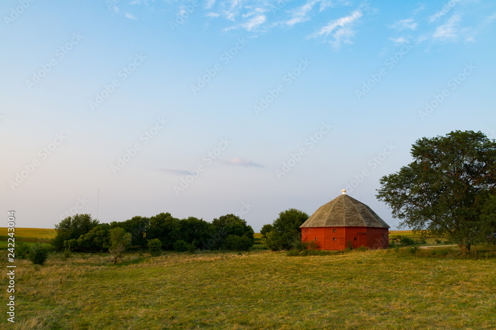 Red round barn in the open field in the late afternoon light.  LaSalle County, Illinois, USA