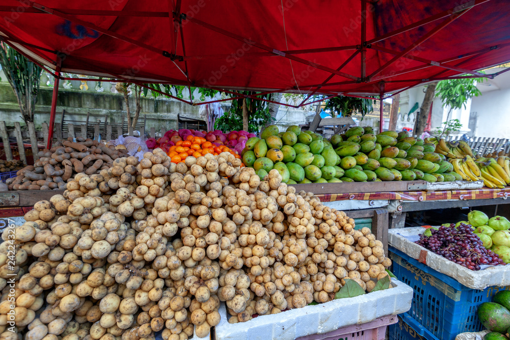 Street counter with tropical vegetables and fruits in a typical Asian market, Southeast Asia, Laos
