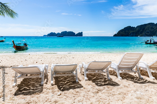 white beach chiar on the san the sea with blue sky and mountain background