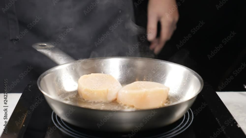 Food concept. Professional chef in gloves frying scallops in slow motion. Clouds of white steam above. Close up. hd Food concept. Professional chef in gloves frying scallops in slow motion. Clouds of white steam above. Close up. hd