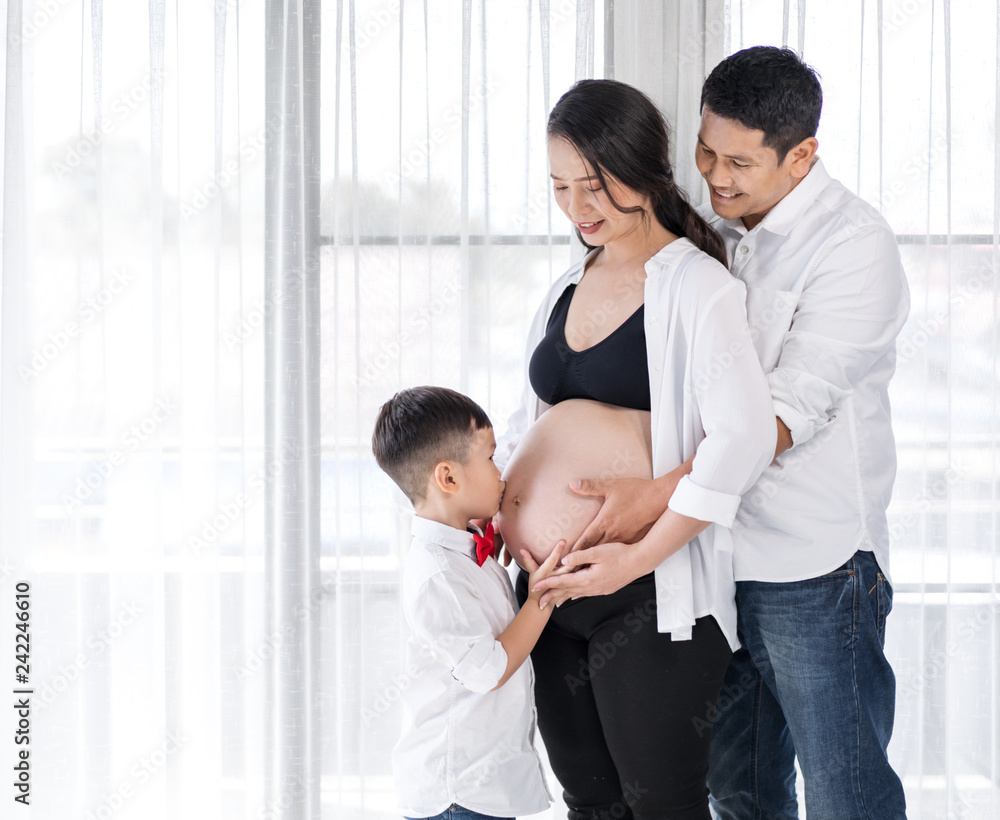 happy family, pregnant mother, father and son kissing happy family, pregnant mother, father and son kissing