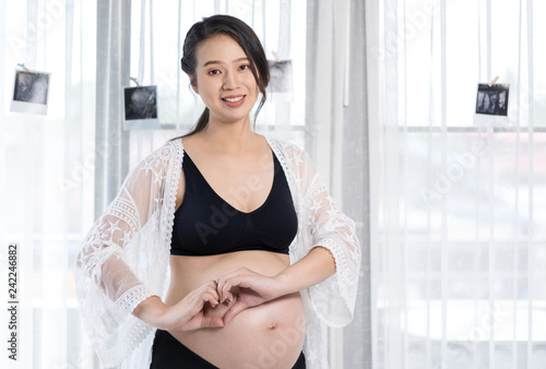 Free Download pregnant woman holding hands in heart shape on belly - GFXLoad