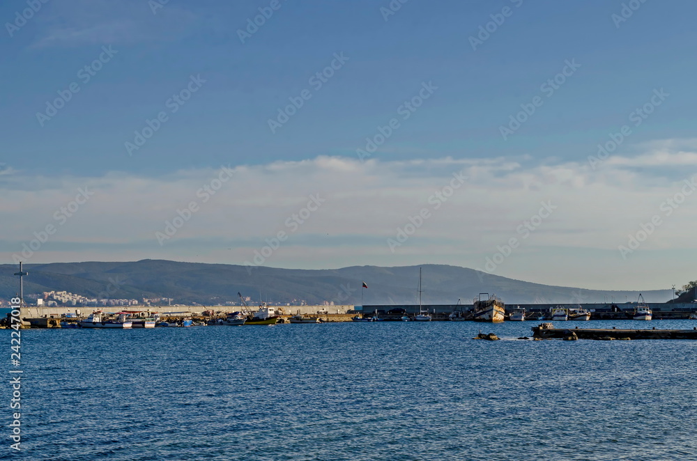 Seascape of pier with cross at end for fishing boat in the Black Sea and Balkan mountain with Cape Emine near ancient city Nessebar, Bulgaria, Europe Seascape of pier with cross at end for fishing boat in the Black Sea and Balkan mountain with Cape Emine near ancient city Nessebar, Bulgaria, Europe