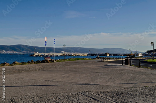 Seascape of pier with cross at end for fishing boat in the Black Sea and Balkan mountain with Cape Emine near ancient city Nessebar, Bulgaria, Europe