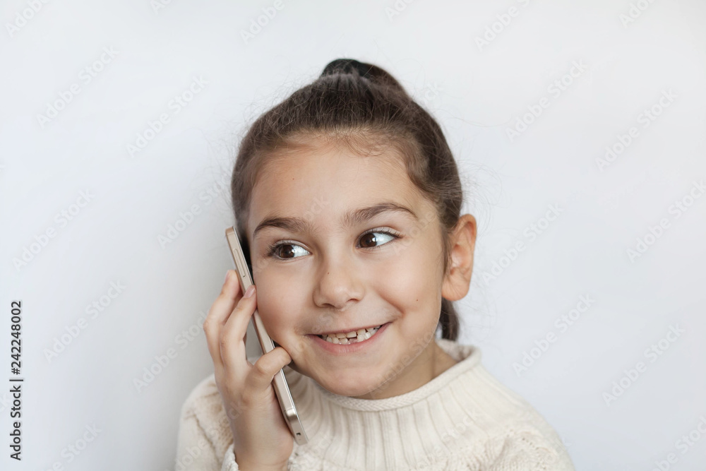 Portrait of a smiling cute girl holding smartphone over white background Portrait of a smiling cute girl holding smartphone over white background