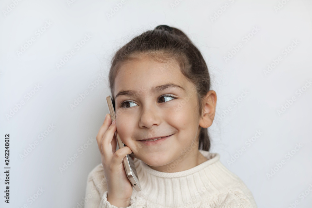 Portrait of a smiling cute girl holding smartphone over white background Portrait of a smiling cute girl holding smartphone over white background