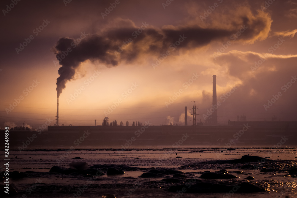 Metallurgical plant with smoking chimneys polluting the atmosphere