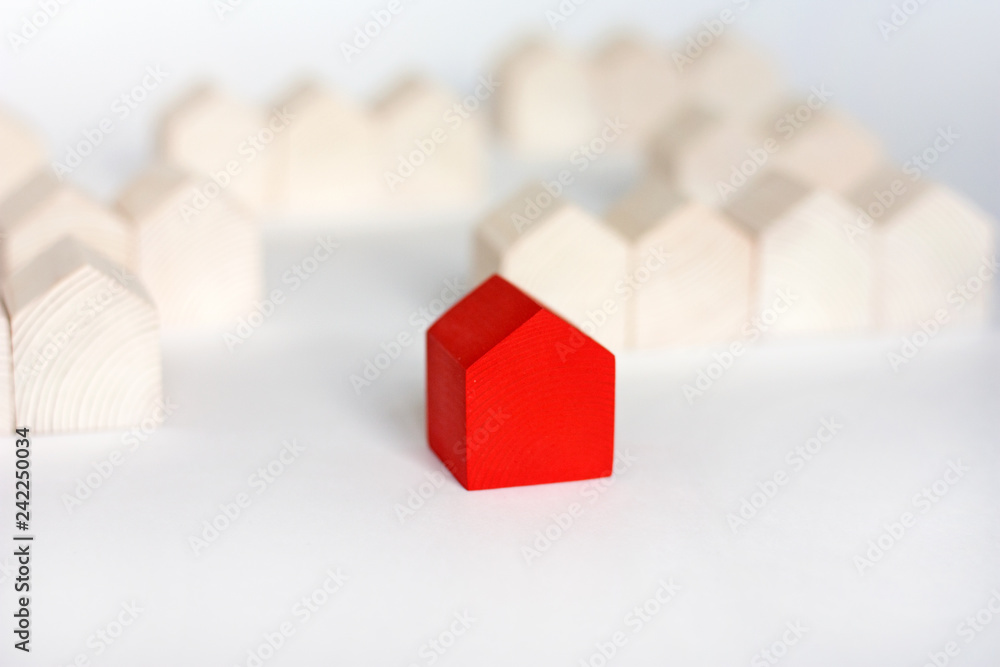 Rows of wooden houses with single red house in center on white background Rows of wooden houses with single red house in center on white background