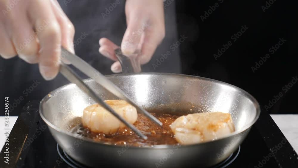 Cooking seafood. healthy food concept. Professional chef in gloves cooking scallops turning them with culnary pliers in slow motion. hd Cooking seafood. healthy food concept. Professional chef in gloves cooking scallops turning them with culnary pliers in slow motion. hd