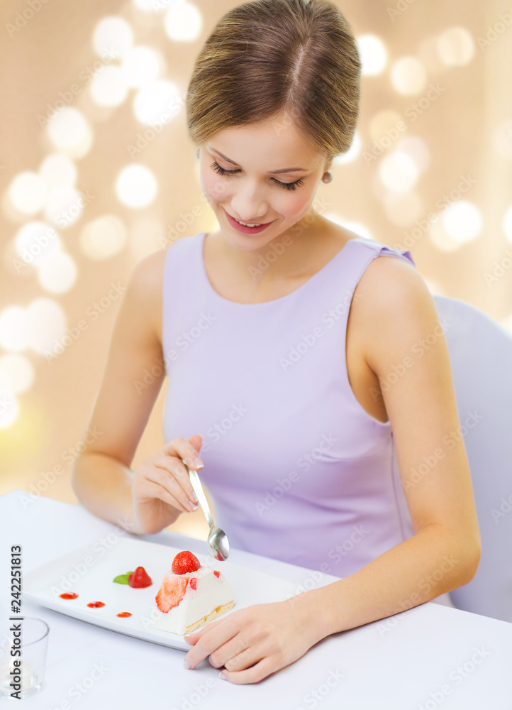 people and food concept - smiling young woman eating dessert at restaurant over festive lights on beige background people and food concept - smiling young woman eating dessert at restaurant over festive lights on beige background