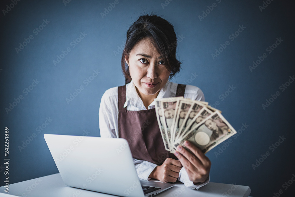 一万円札を持って真剣な表情の女性