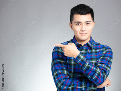 smiling young man pointing copy space