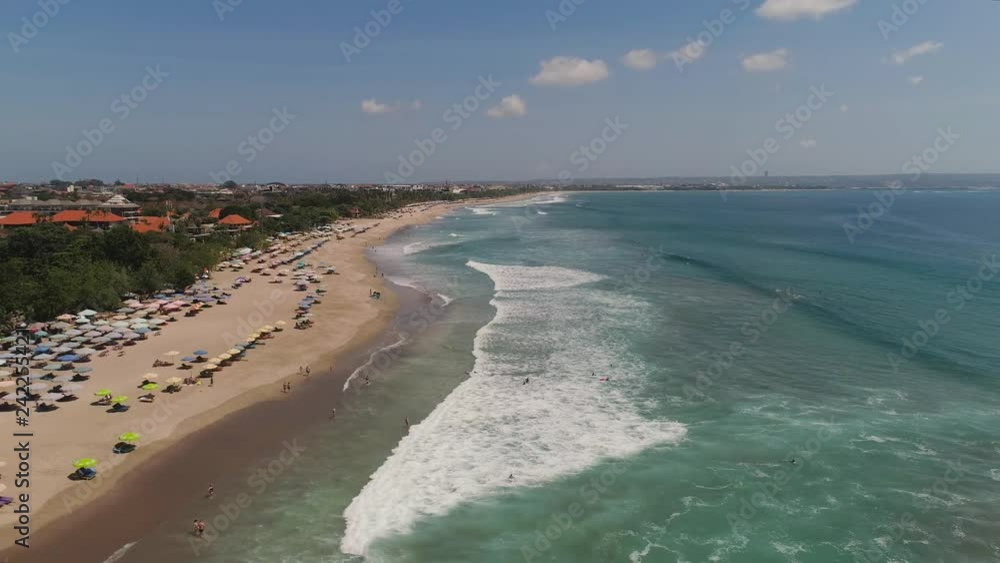 Aerial view sand beach with surfers and tourists, Kuta, Bali. surfers on water surface ocean catch wave. Seascape, beach, ocean, sky sea Travel concept
