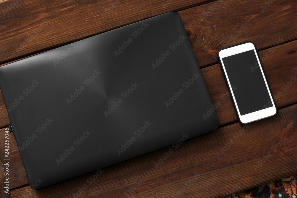 Laptop and phone on wooden background Laptop and phone on wooden background