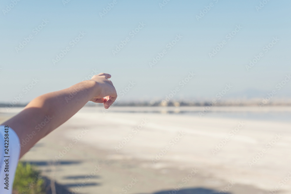 A boy finger shows on the salt lake in Larnaca. Cyprus A boy finger shows on the salt lake in Larnaca. Cyprus