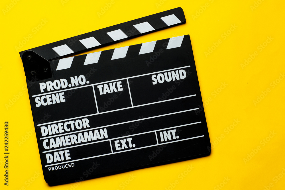 Movie clapper on a yellow background with copy space. Flat lay.