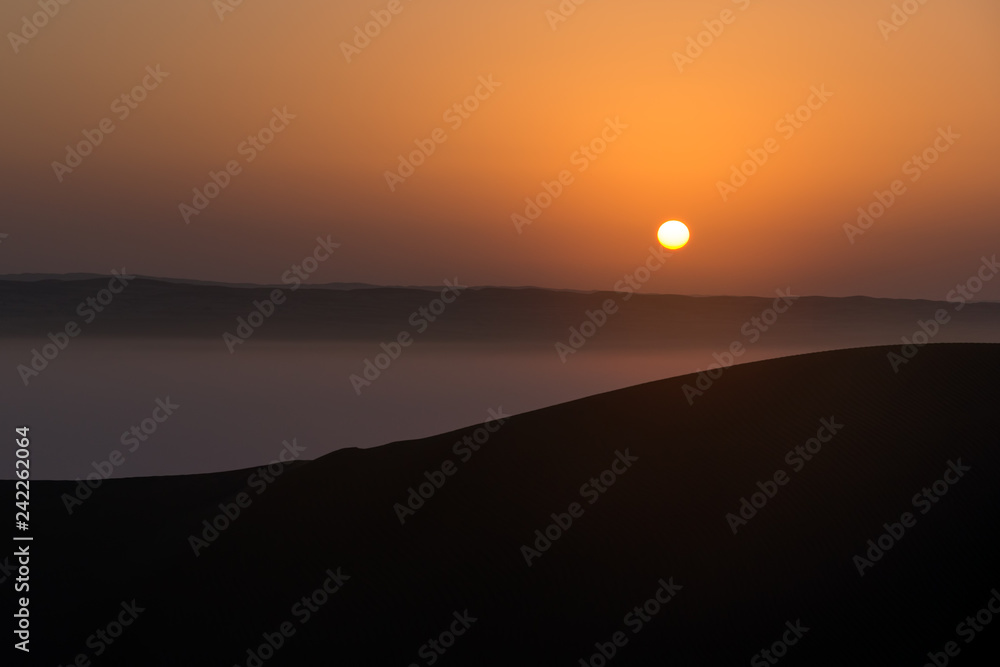 Sunrise with mist in Wahiba Sands desert in Oman