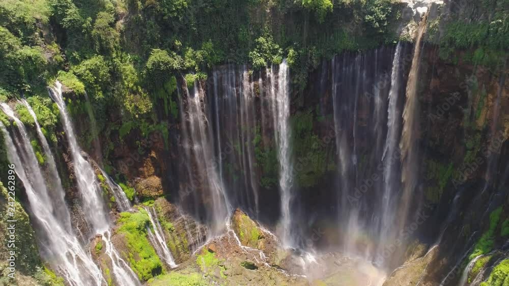 beautiful waterfall Coban Sewu in tropical forest, Java Indonesia. aerial view tumpak sewu waterfall in rainforest aerial footage