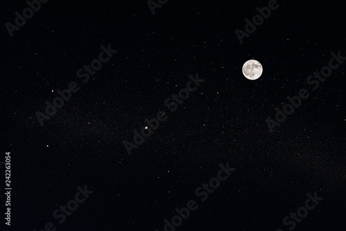 Huge full moon on the night black sky with bright stars. © flowertiare