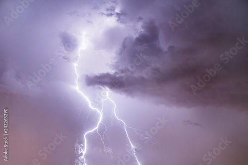 Closeup of lightning strike on the night cloudy sky.