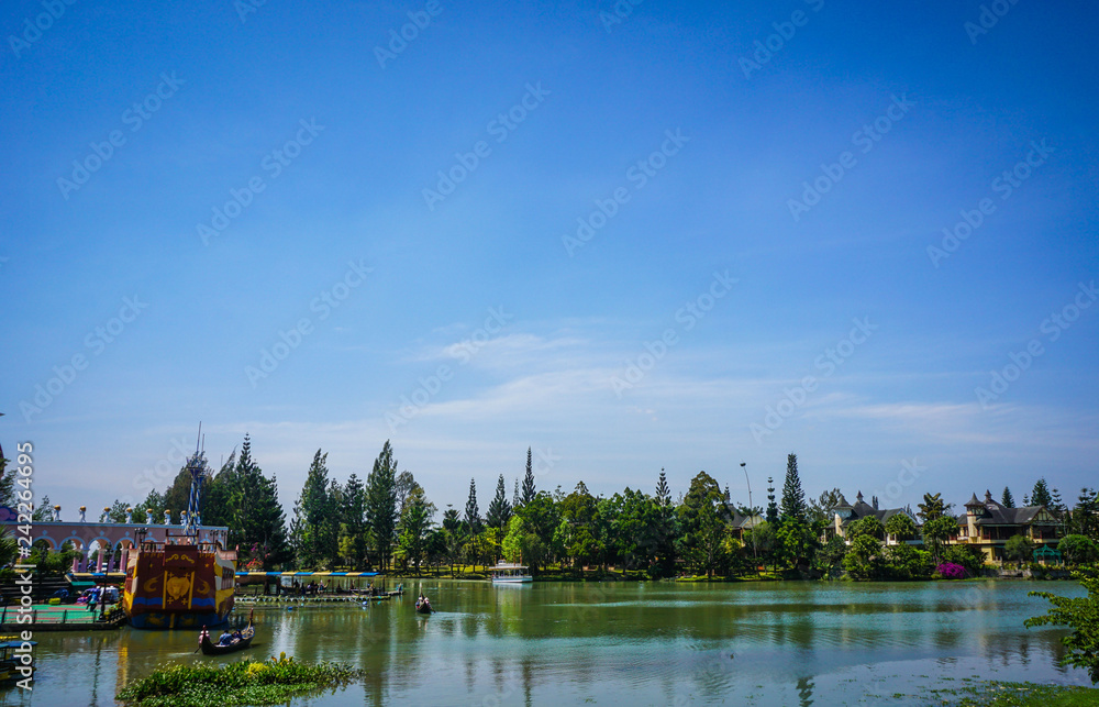 a clear blue sky with green lake water and forest as background in indonesia