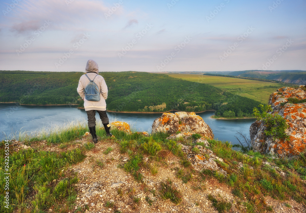 tourist over the canyon of the picturesque river. girl stands on a cliff above the canyon. autumn morning