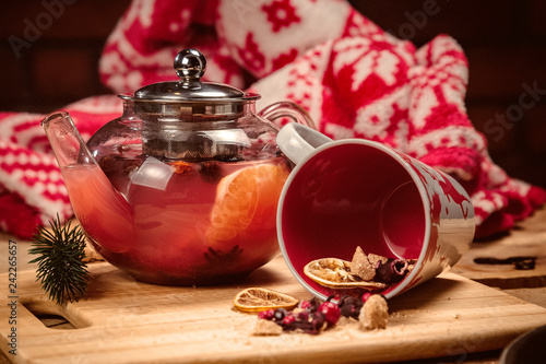 composition teapot with tea, a mug with a deer, dried oranges, berries