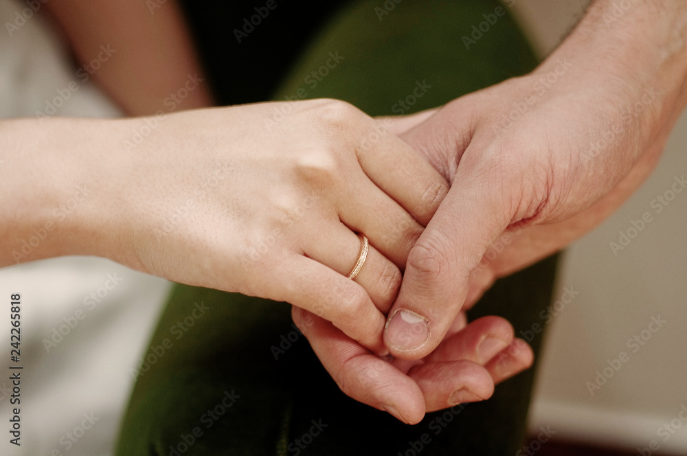 Lovers couple, man and woman, hold hands, close-up. Valentine's Day, Wedding Day, love story or romantic background