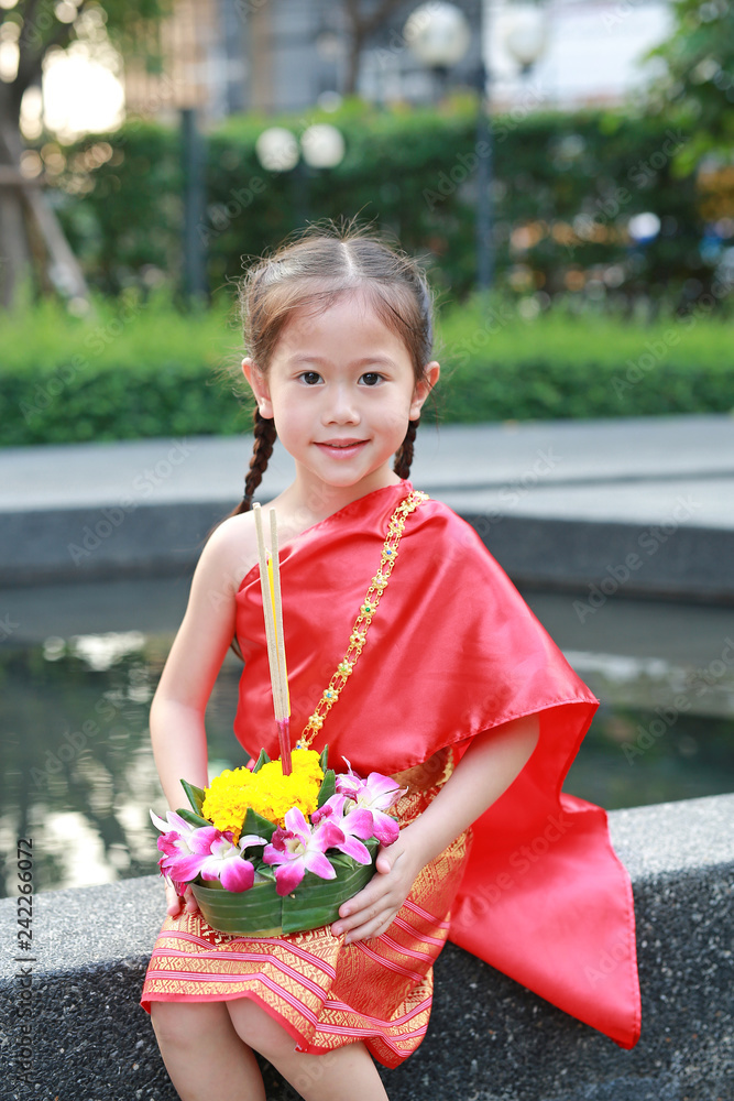 Loy Krathong festival, Asian Child girl in Thai traditional dress with holding krathong for forgiveness Goddess Ganges to celebrate festival in Thailand. Loy Krathong festival, Asian Child girl in Thai traditional dress with holding krathong for forgiveness Goddess Ganges to celebrate festival in Thailand.