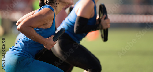 Mud race runners, group of racers squat with a dumbbell