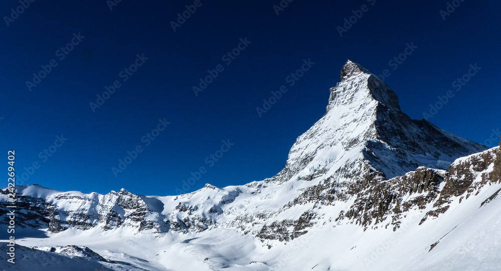 A wonderful image of the north face of the world famous Matterhorn and surrounding rock formations on a beautiful clear winterday in the ski area of Zermatt in the Swiss Alps