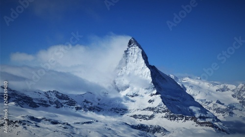 A wonderful panoramic image of the north face of the world famous Matterhorn partly covered in clouds on a further clear day in the ski area of Zermatt in the Swiss Alps