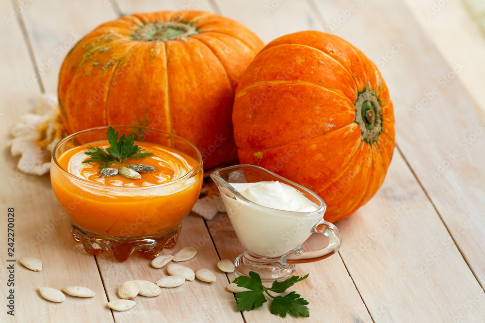 home made pumpkin cream soup with pumpkins and parsley leaves on white wooden table. cream soup of pumpkin home made pumpkin cream soup with pumpkins and parsley leaves on white wooden table. cream soup of pumpkin
