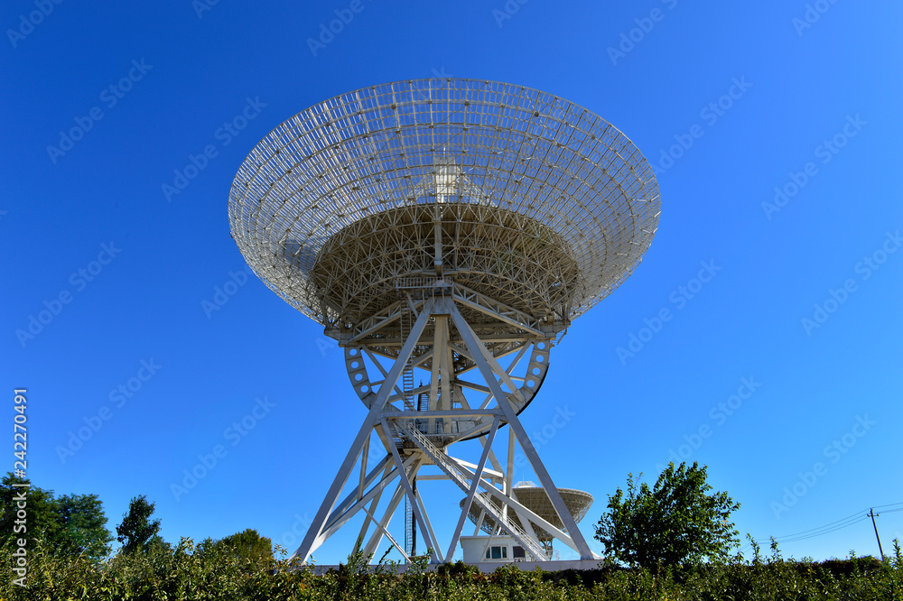 Array of satellite dishes or radio antennas against sky. Space o