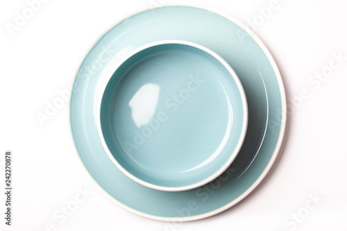 Empty pastel blue plate and bowl on white background