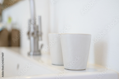 white ceramic cups in blurred bathroom background