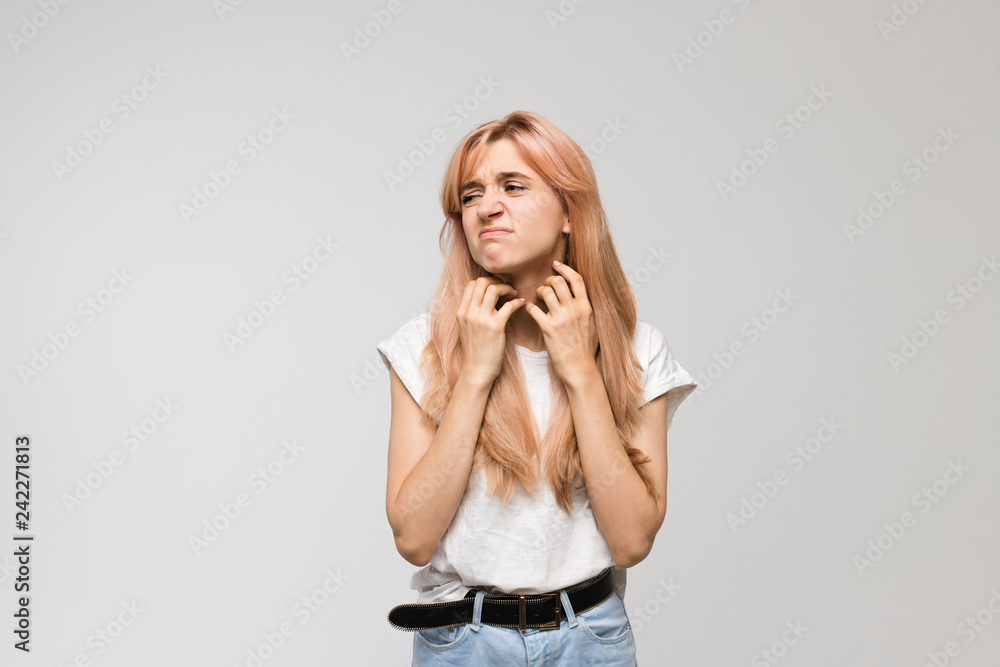Isolated studio portrait of young beautiful woman in white shirt scratching neck/irritation, sensitive skin, allergy symptoms, rhinitis, cold, itch, healthcare and medicine concept. Isolated studio portrait of young beautiful woman in white shirt scratching neck/irritation, sensitive skin, allergy symptoms, rhinitis, cold, itch, healthcare and medicine concept.