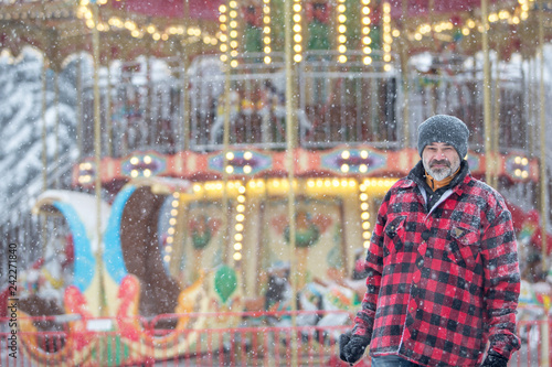 man in a warm jacket near the Victorian carousel