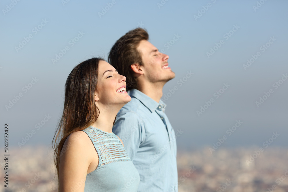 Happy couple breathing fresh air with urban background Happy couple breathing fresh air with urban background